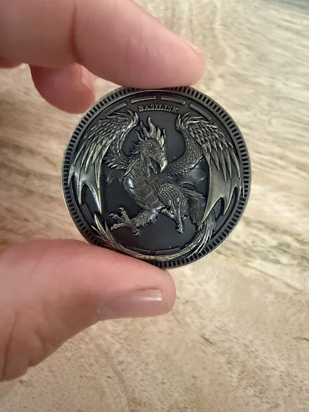 Basilisk face of the Mythic Mash coin held in hand